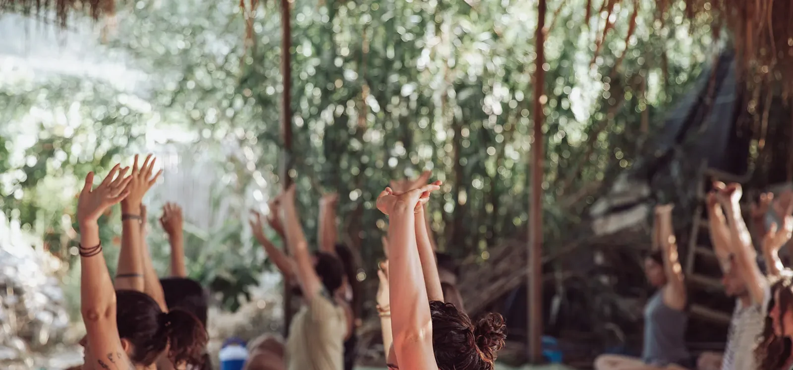 קבוצת משתתפים מרימה ידיים יחד בתנועה, מריטריט קודם