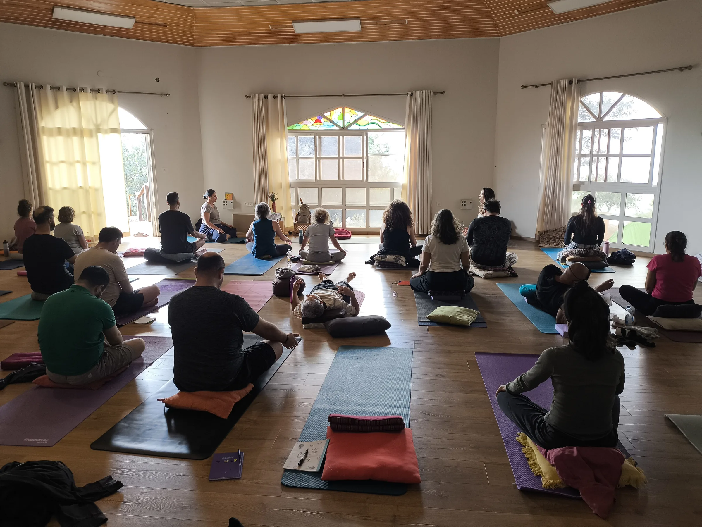קבוצת משתתפים יושבת במדיטציה באולם התרגול, מריטריט קודם